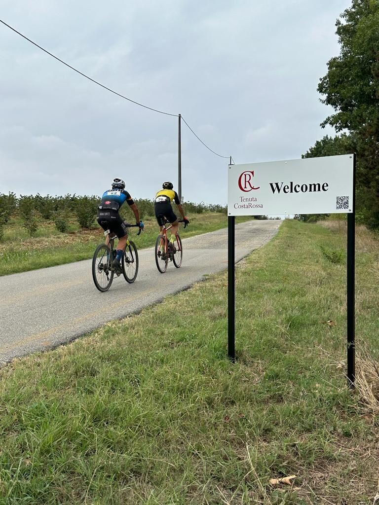 cyclist just passing the welcome sign at Tenuta CostaRossa